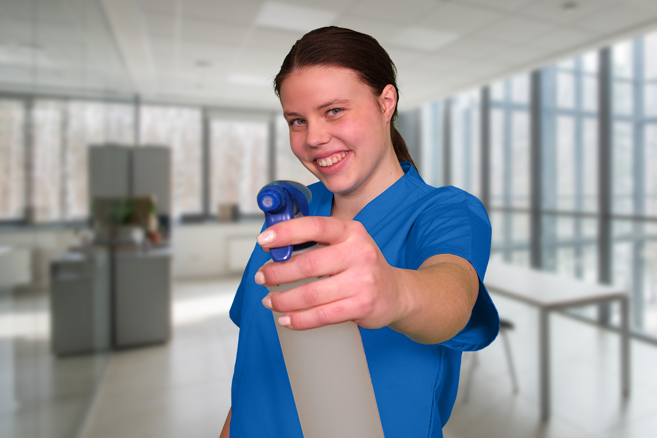 Eine Mitarbeiterin der Büroreinigung Hannover mit einer Sprühflasche