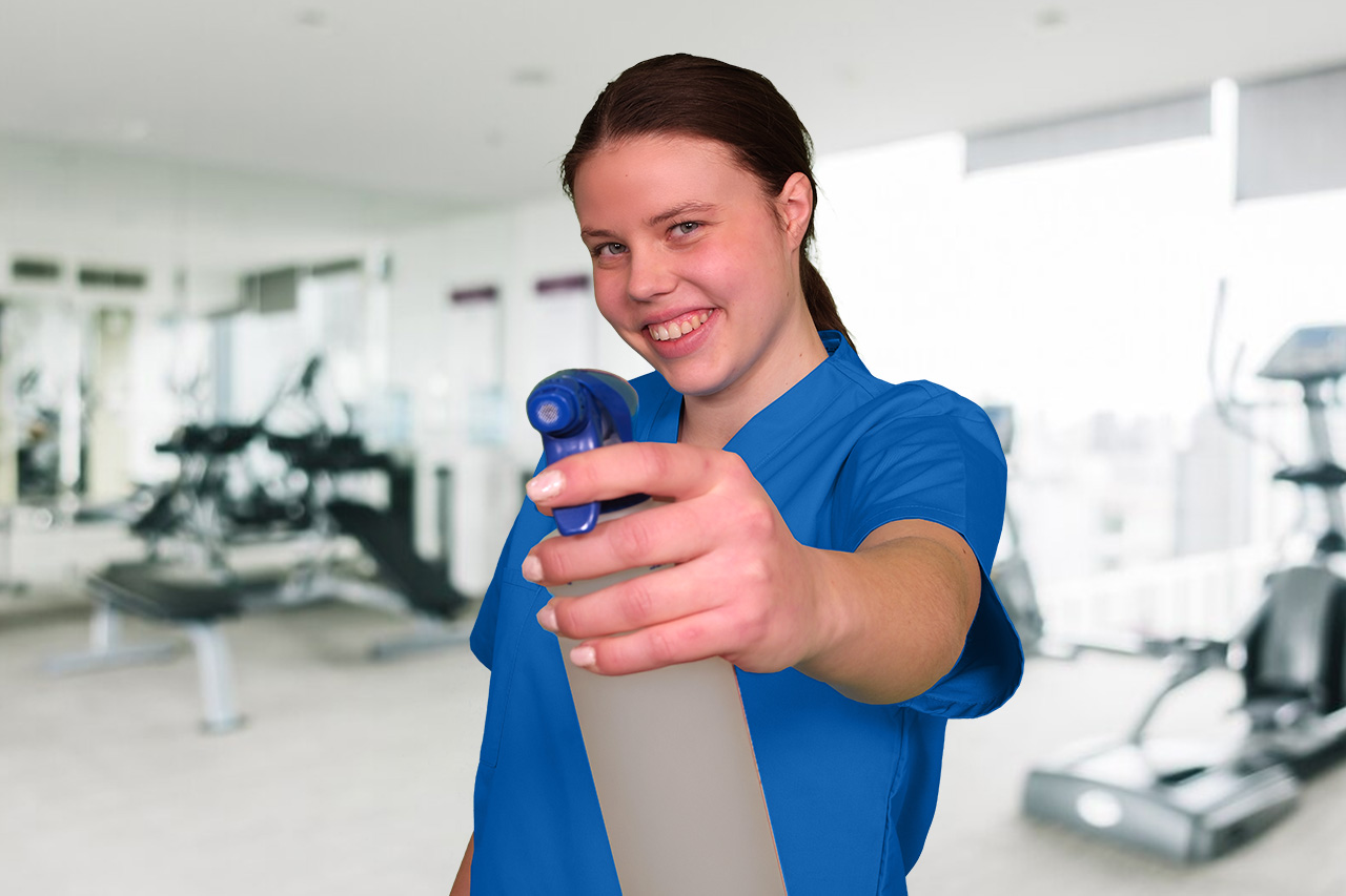 Eine Mitarbeiterin der Fitnesscenter-Reinigung Hannover mit einer Sprühflasche