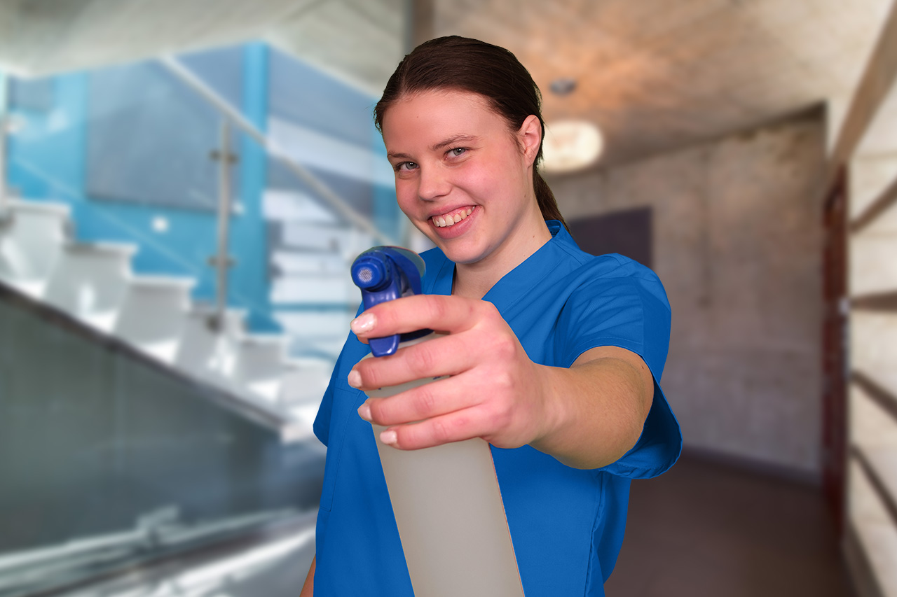 Eine Mitarbeiterin der Treppenhausreinigung Hannover mit einer Sprühflasche