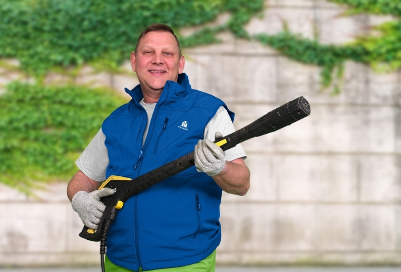 Ein Mitarbeiter der Fassadenreinigung Hannover mit einem Hochdruckreiniger
