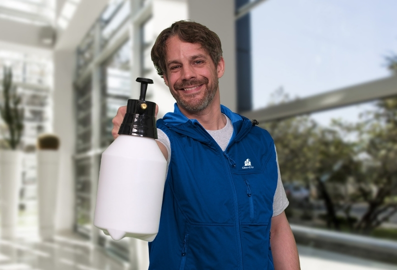 Ein Mitarbeiter der Hausmeisterdienste Hannover mit einer Sprühflasche